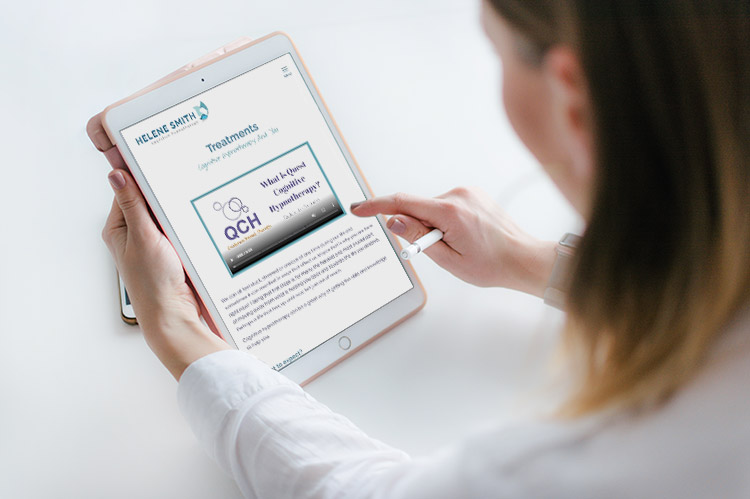 A woman scrolling on a tablet showing the Helene Smith Cognitive Hypnotherapist website.