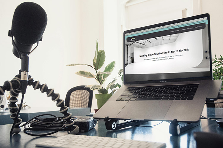 Creative Klousions website displayed on a laptop in an office environment